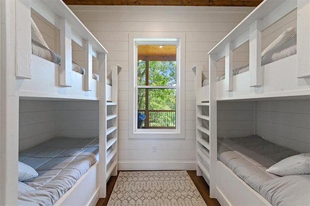 bedroom with wood walls and hardwood / wood-style floors