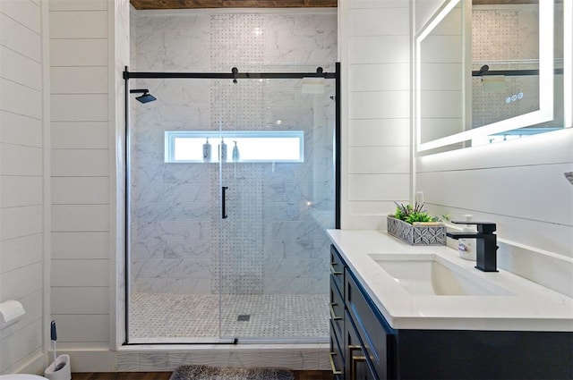 bathroom with a shower with door and vanity