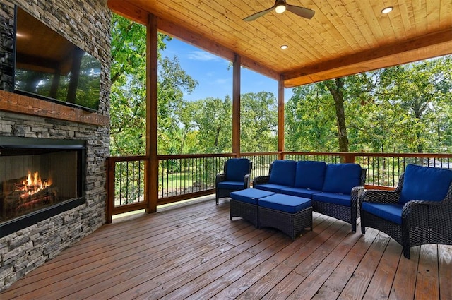 wooden deck featuring an outdoor living space with a fireplace and ceiling fan