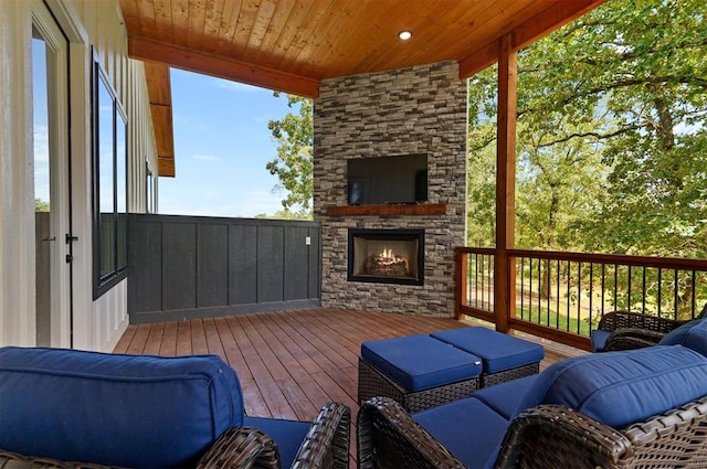 wooden terrace with an outdoor stone fireplace