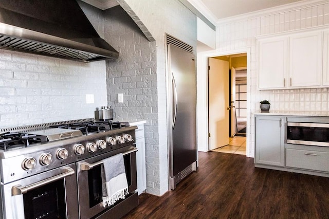 1405 Rosehaven Dr, Altus, OK 73521 - kitchen with built in appliances, wall chimney exhaust hood, ornamental molding, light countertops, and backsplash