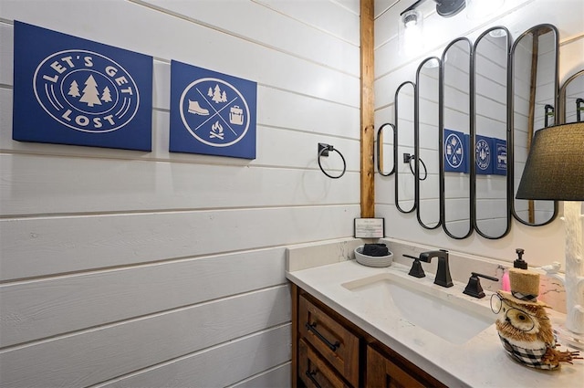 bathroom with vanity and wooden walls