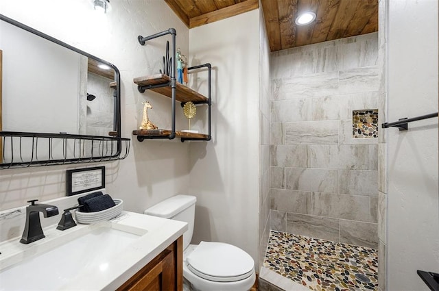 bathroom with tiled shower, vanity, toilet, and wood ceiling