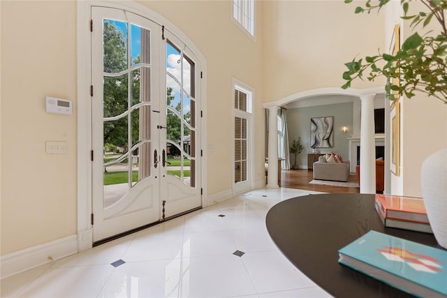 doorway to outside featuring french doors, decorative columns, and light tile patterned flooring