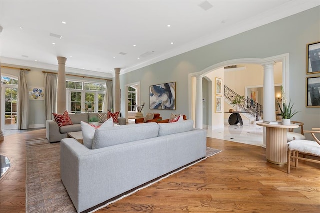 living room with ornamental molding, decorative columns, light hardwood / wood-style flooring, and a healthy amount of sunlight