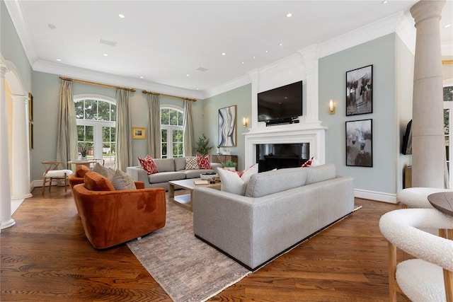 living room featuring ornate columns, crown molding, a fireplace, and dark wood-type flooring