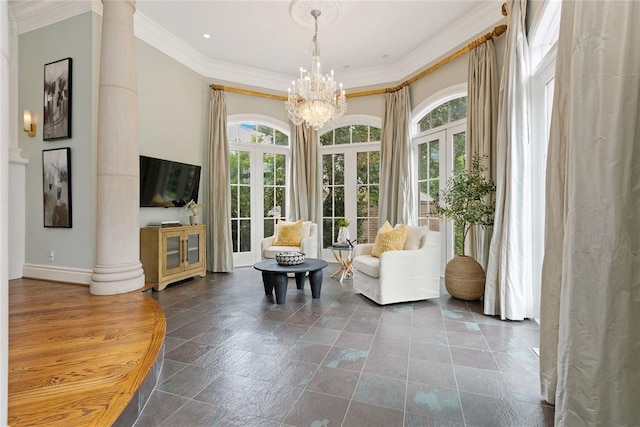 interior space with a chandelier, french doors, decorative columns, and crown molding