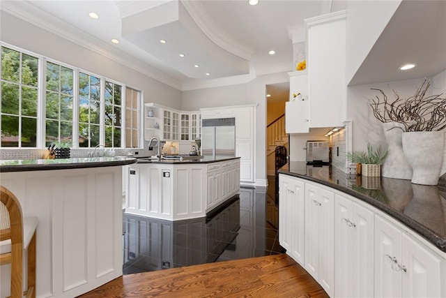 kitchen with white cabinets, ornamental molding, and stainless steel built in refrigerator