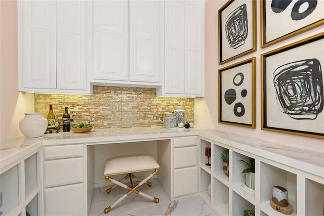 bar with white cabinets, light stone counters, and backsplash