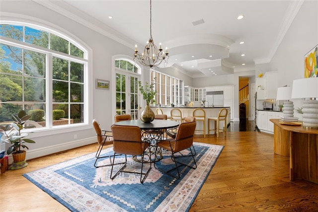 dining room featuring a healthy amount of sunlight, light hardwood / wood-style floors, and crown molding