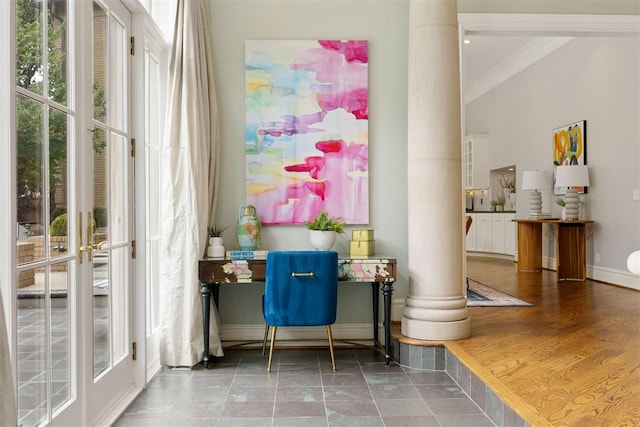 interior space with wood-type flooring, decorative columns, a wealth of natural light, and ornamental molding