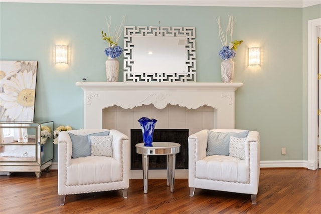 sitting room featuring wood-type flooring and ornamental molding