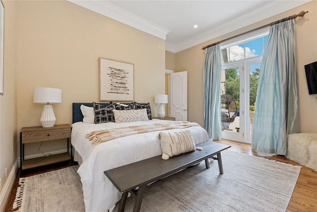 bedroom with access to exterior, wood-type flooring, and crown molding