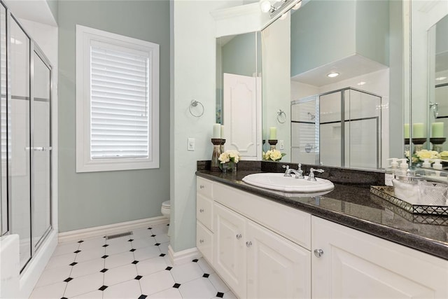 bathroom with vanity, toilet, and an enclosed shower