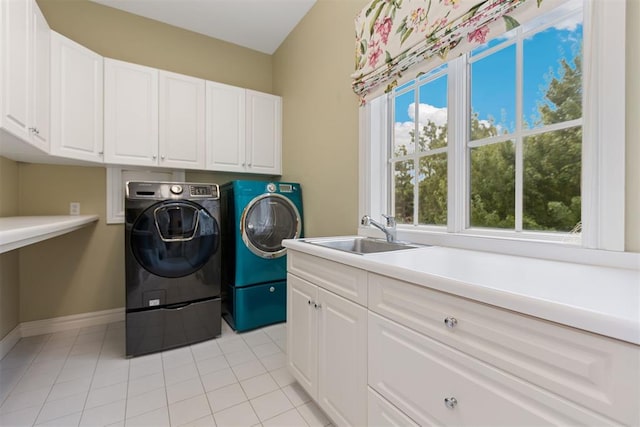 laundry room with cabinets, light tile patterned floors, washing machine and dryer, and sink