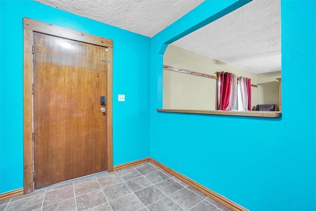 entryway featuring tile patterned flooring and a textured ceiling