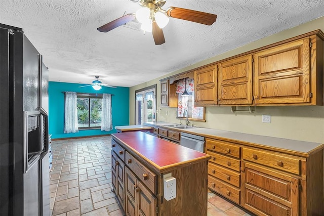 kitchen featuring a center island, sink, stainless steel dishwasher, a textured ceiling, and black fridge with ice dispenser