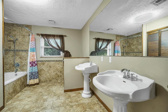 bathroom with a textured ceiling and shower / tub combo with curtain