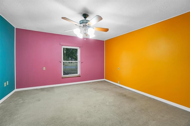 spare room with a textured ceiling, carpet floors, and ceiling fan