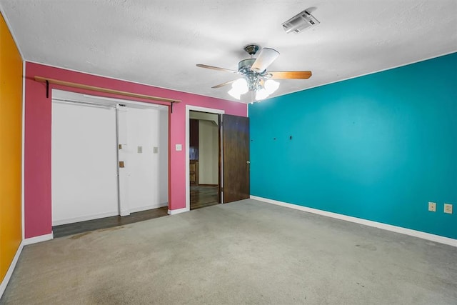 unfurnished bedroom with ceiling fan and a textured ceiling