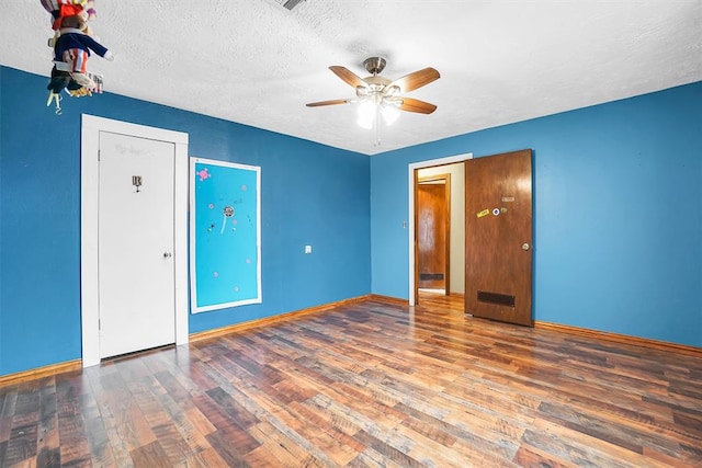 unfurnished bedroom with ceiling fan, dark wood-type flooring, and a textured ceiling