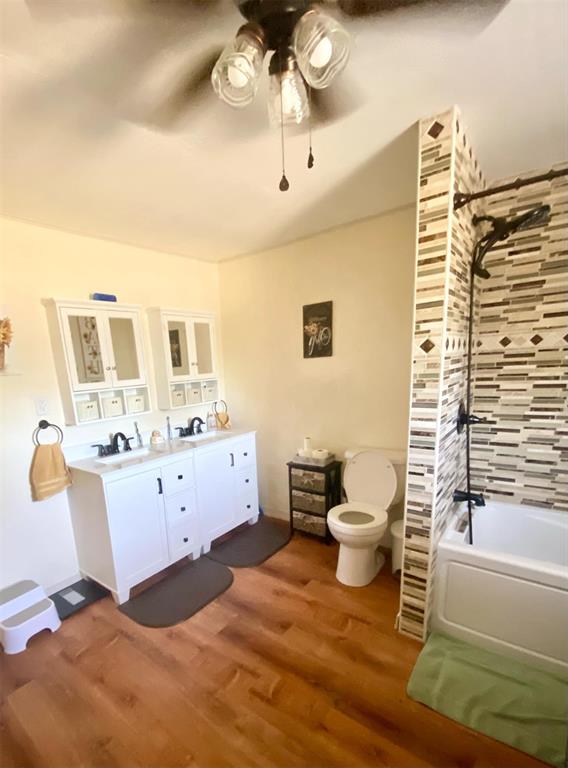 bathroom featuring hardwood / wood-style floors, vanity, ceiling fan, and bathtub / shower combination