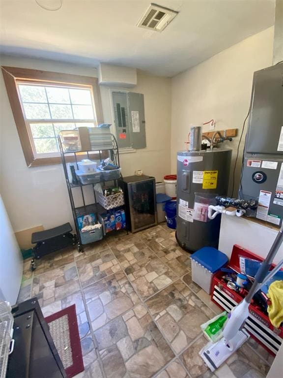 storage room featuring electric panel and electric water heater