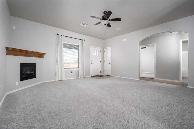 unfurnished living room featuring carpet floors and ceiling fan