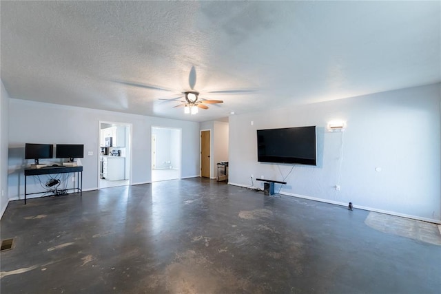 unfurnished living room featuring ceiling fan, a textured ceiling, and washer / clothes dryer