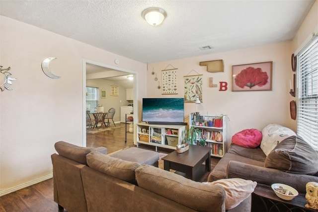 living room with dark wood-type flooring and a textured ceiling