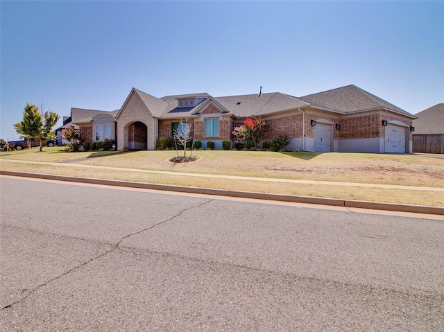 single story home featuring a garage and a front lawn