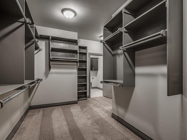 walk in closet with light colored carpet