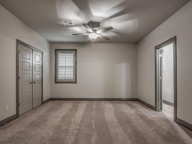 unfurnished bedroom with light colored carpet and ceiling fan