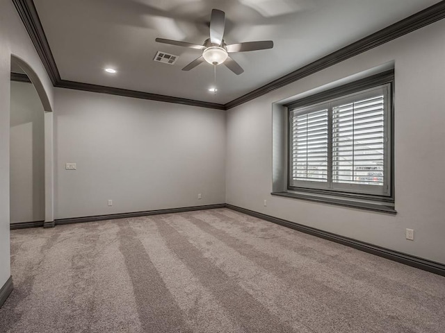 carpeted spare room with ceiling fan and crown molding