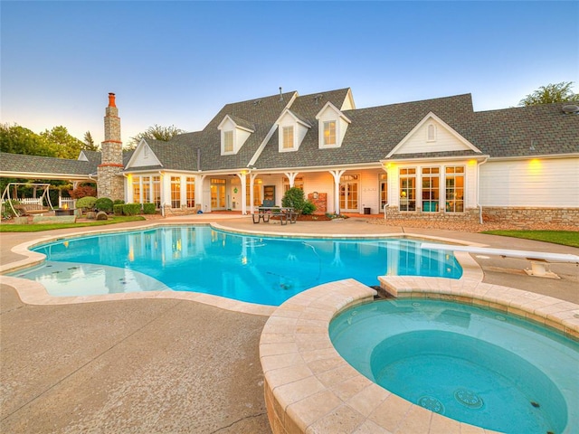 view of pool with an in ground hot tub, a patio, and a diving board