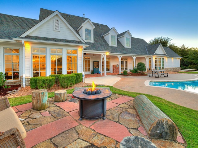 rear view of property with a patio and a fire pit