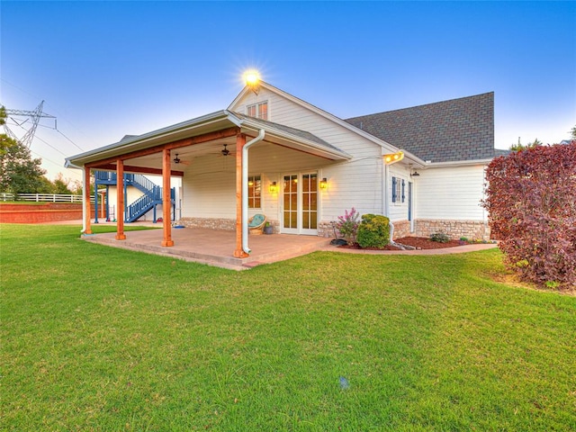 rear view of property with ceiling fan, a yard, and a patio