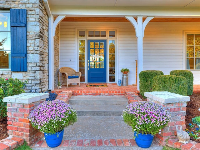 view of exterior entry featuring covered porch