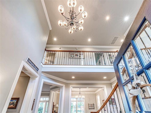 interior space with ornamental molding, a notable chandelier, and a high ceiling