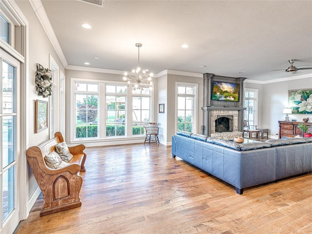 living room with light wood-type flooring, a wealth of natural light, and ornamental molding