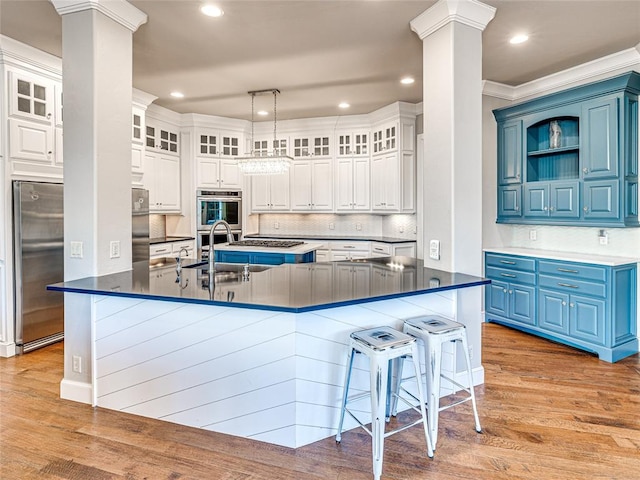 kitchen with blue cabinetry, stainless steel appliances, light hardwood / wood-style floors, white cabinets, and ornamental molding