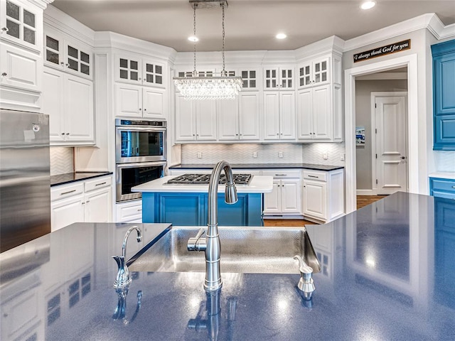 kitchen featuring white cabinetry, decorative light fixtures, decorative backsplash, a kitchen island, and appliances with stainless steel finishes