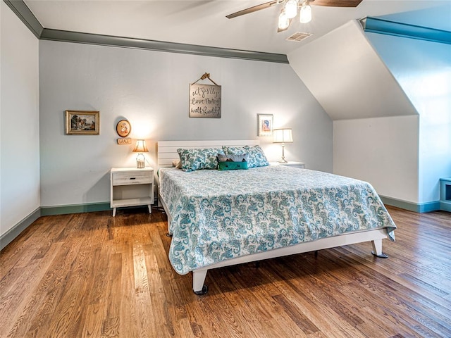 bedroom featuring ceiling fan, wood-type flooring, lofted ceiling, and ornamental molding