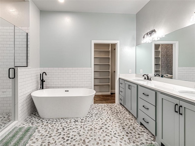 bathroom with tile patterned flooring, vanity, separate shower and tub, and tile walls