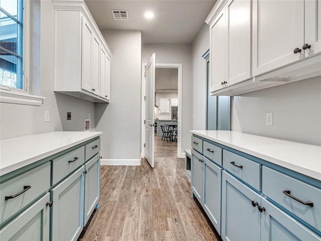 kitchen with white cabinets and light hardwood / wood-style flooring