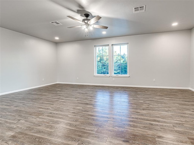 spare room featuring ceiling fan and dark wood-type flooring