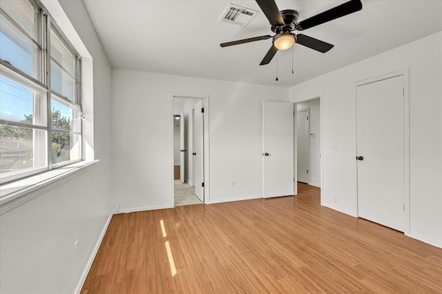 unfurnished bedroom with connected bathroom, ceiling fan, and light hardwood / wood-style flooring