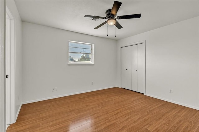 unfurnished bedroom featuring light wood-type flooring, a closet, and ceiling fan