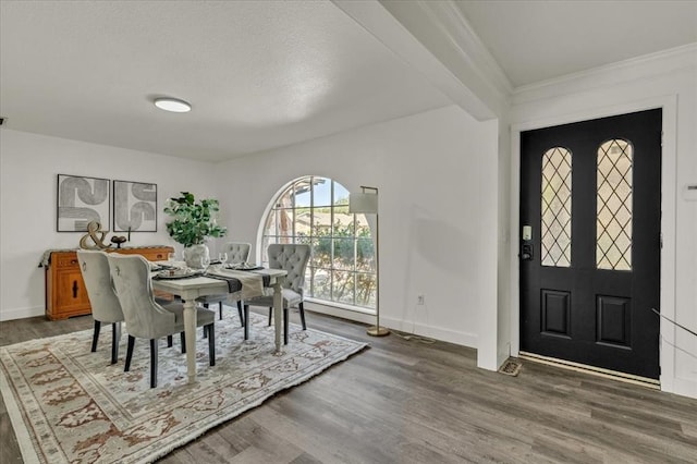 dining area with beamed ceiling and dark hardwood / wood-style floors