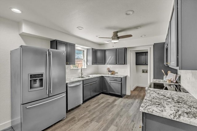 kitchen featuring gray cabinets, ceiling fan, sink, and stainless steel appliances